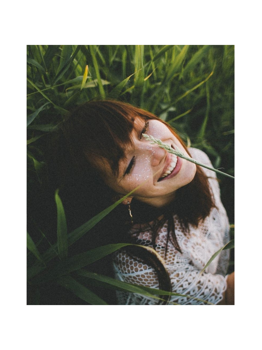 Dana lying in tall grass and smiling